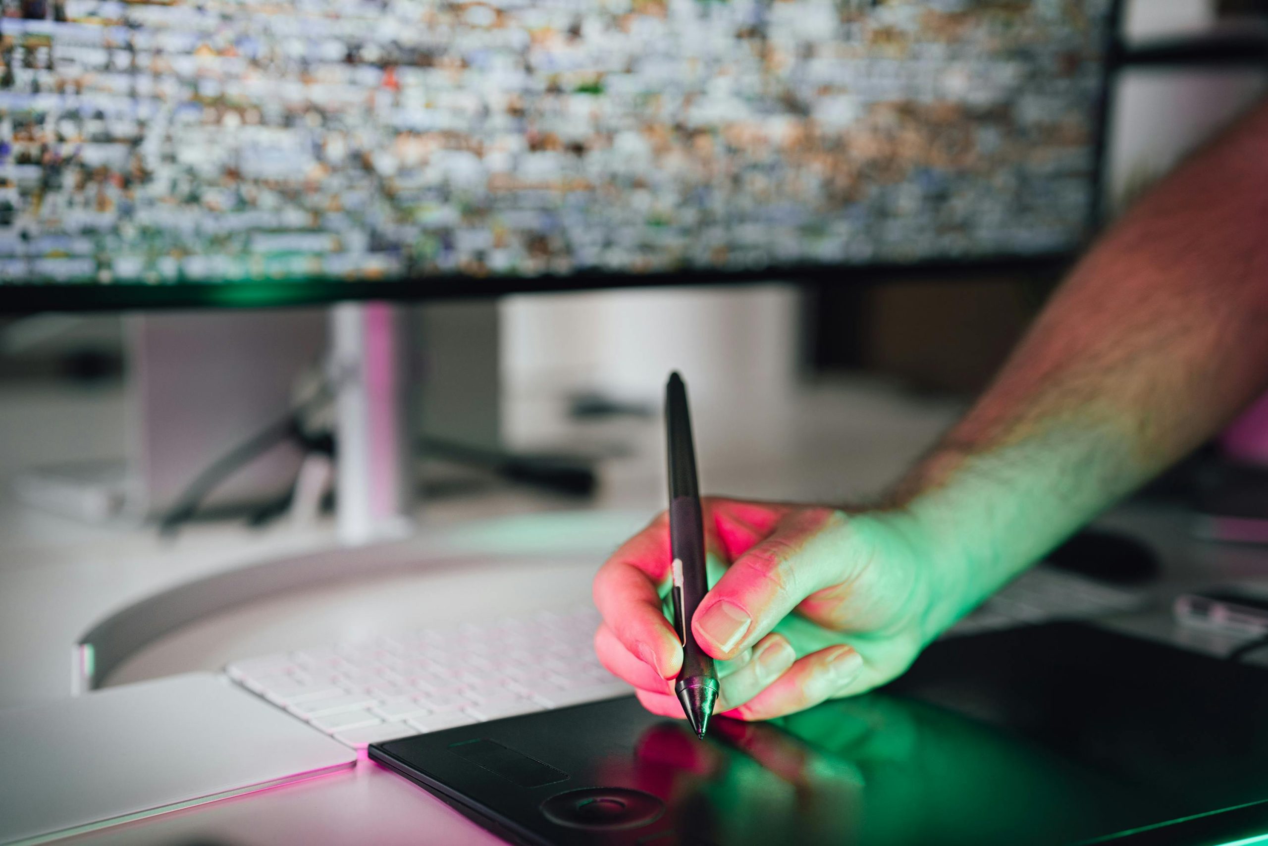 A digital artist using a graphics tablet and stylus in a modern workspace. High-tech creative process.